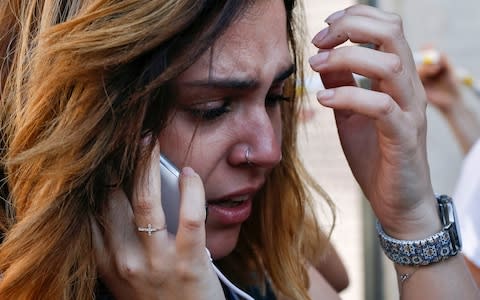 A woman cries as she phones after a van ploughed into the crowd, killing one person and injuring several others on the Rambla in Barcelona on August 17, 2017 - Credit: AFP