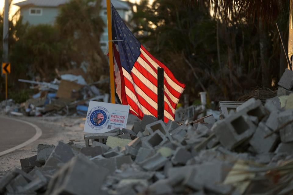 The American flag flies amid debris along a roadside on Estero Island, which was heavily damaged by Hurricane Ian in Fort Myers Beach, Florida (Copyright 2022 The Associated Press. All rights reserved.)