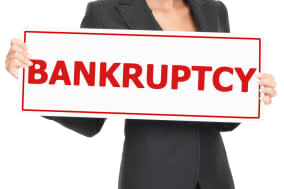 Bankruptcy sign being held by woman in business suit