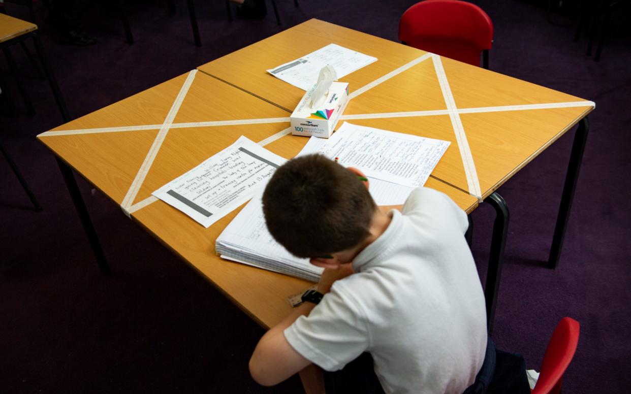 Social distancing measures as a child studies on a marked table at Kempsey Primary School in Worcester. - Jacob King/PA