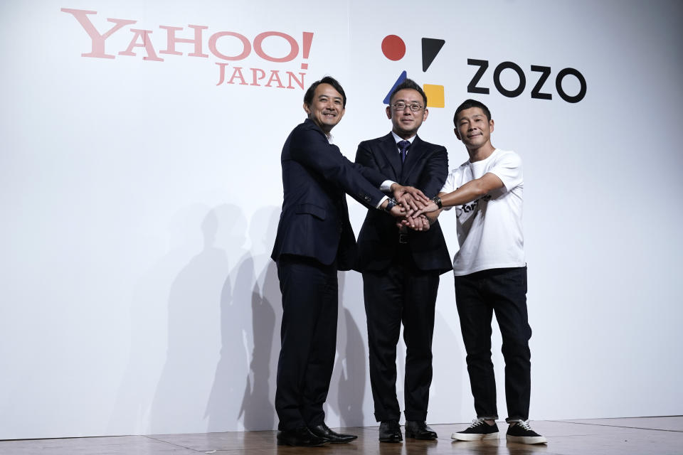 Yahoo Japan President, Kentaro Kawabe, from left, Zozo's new president, Kotaro Sawada, and Zozo founder, Yusaku Maezawa, pose for photos during a news conference Thursday, Sept. 12, 2019, in Tokyo. (AP Photo/Jae C. Hong)