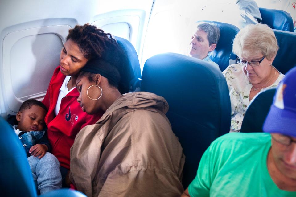 Former Washington Mystics player Tayler Hill and her son, Maurice, get some sleep on the shoulder of teammate Tierra Ruffin-Pratt while sitting in coach on a 2015 commercial flight.