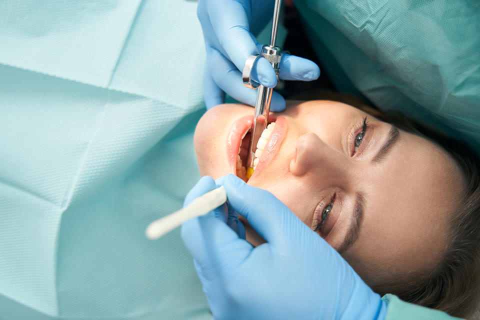 a patient's teeth getting examined by a dentist