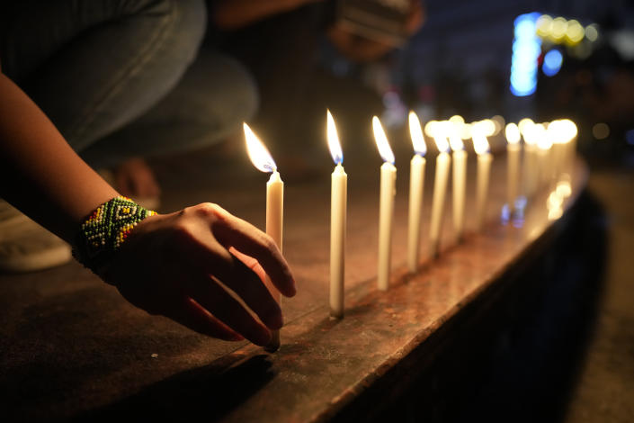 Activists light candles as they condemn the killing of Filipino journalist Percival Mabasa during a rally in Quezon, Philippines, Tuesday Oct. 4, 2022. Motorcycle-riding gunmen killed the longtime radio commentator in the latest attack on a member of the media in the Philippines, considered one of the world's most dangerous countries for journalists. (AP Photo/Aaron Favila)