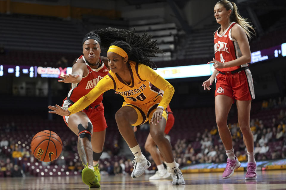 Minnesota guard Janay Sanders, center, and Ohio State forward Cotie McMahon, left, reach for the ball during the first half of an NCAA college basketball game Thursday, Feb. 8, 2024, in Minneapolis. (AP Photo/Abbie Parr)