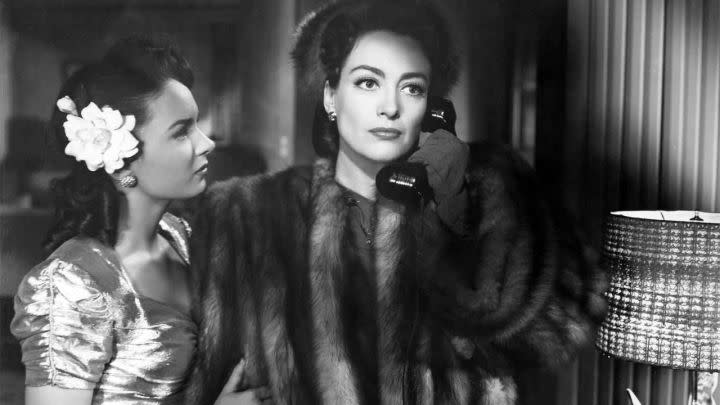 Ann Blyth as Veda Pierce looking at Joan Crawford as Mildred Pierce on the phone in Mildred Pierce.