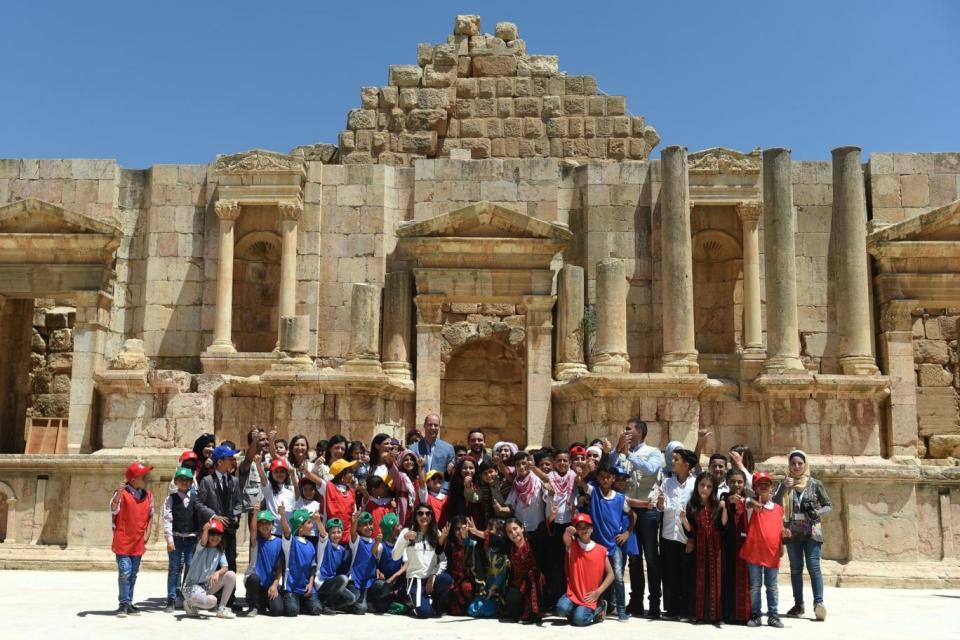 Jerash: William and the Crown Prince pose with local schoolchildren at the spot (PA)