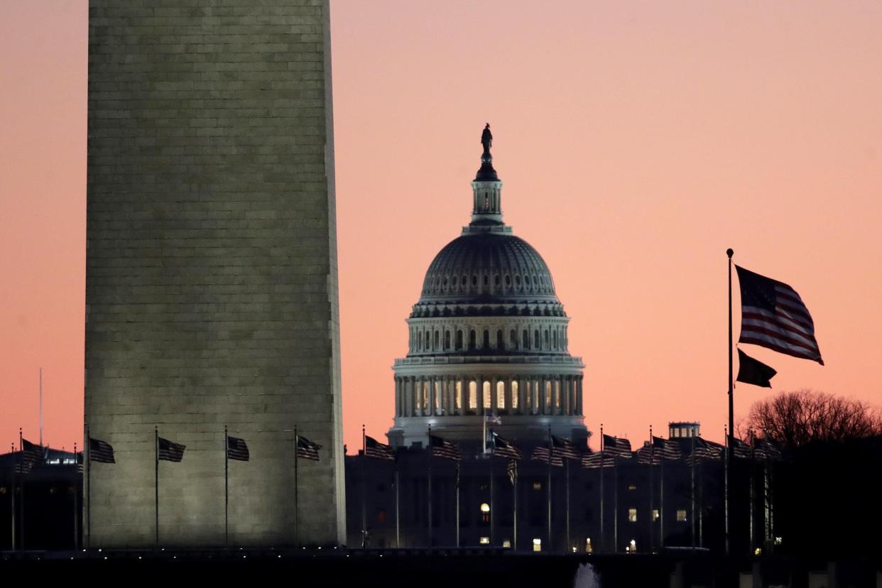The U.S. Capitol building is seen next to the bottom part of the Washington Monument before sunrise on Dec. 19, 2019.