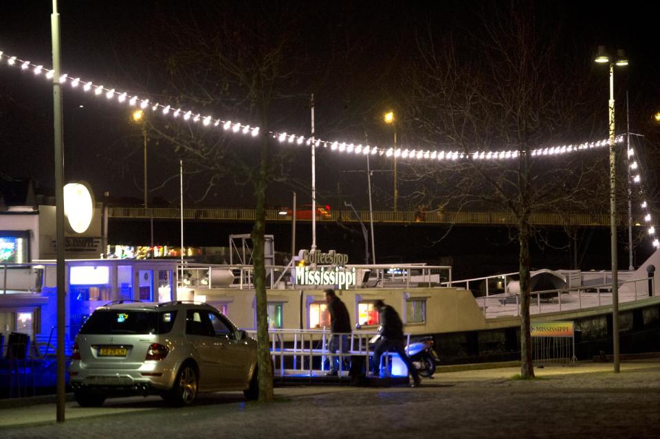 In this photo taken Friday, Dec. 20, 2013, visitors enter coffee shop Mississippi in Maastricht, southern Netherlands. While several U.S. states have moved to legalize the sale of marijuana, the Netherlands is going in the opposite direction, clamping down on its famed tolerance policy toward weed. In Maastricht, attempts to ban foreigners from buying weed have led to a resurgence of street-dealers, while Amsterdam is shutting marijuana cafes located too close to schools. (AP Photo/Ermindo Armino)