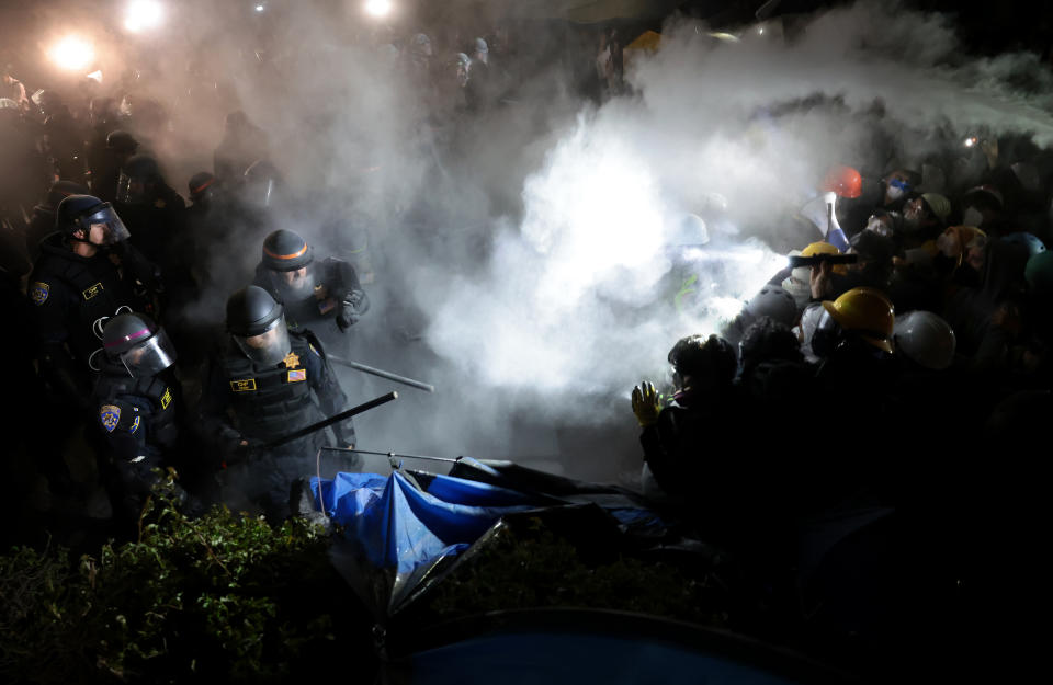 Police officers clash with pro-Palestinian protesters as a fire extinguisher is deployed at UCLA early Thursday morning.