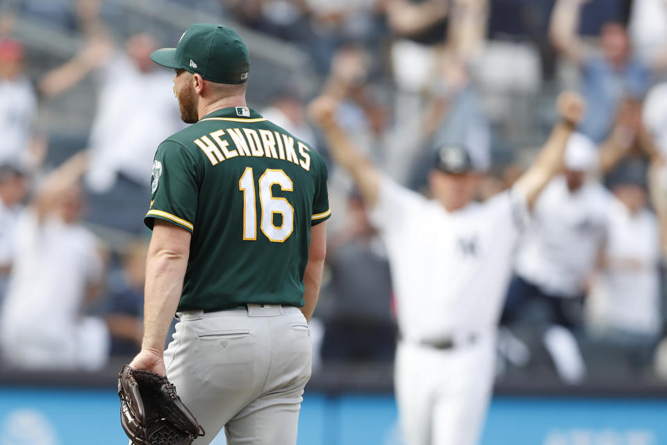 Oakland Athletics relief pitcher Liam Hendriks (16) leaves the mound as New York Yankees' third base coach Phil Nevin celebrates, right, after the Yankees' Mike Ford hit a pinch-hit, walk-off, solo home run in the ninth inning of a baseball game, Sunday, Sept. 1, 2019, in New York. (AP Photo/Kathy Willens)