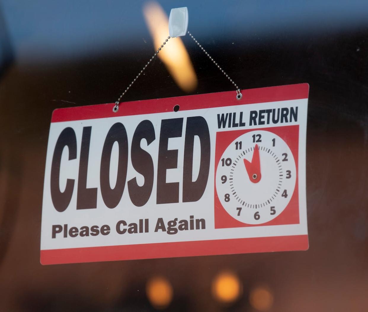 A closed sign hangs in a store window. (Adrian Wyld/The Canadian Press - image credit)