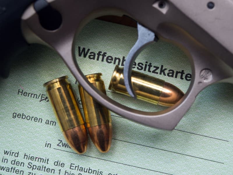 A 9 mm pistol and bullets sit on a gun license in Frankfurt Oder. Patrick Pleul/dpa-Zentralbild/dpa