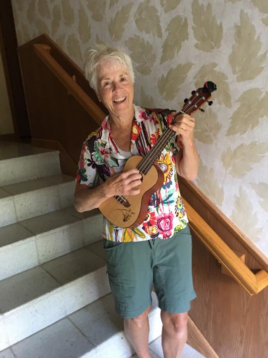 In this undated photo, Pat Adamson-Waitley, 62, poses with her ukulele at her home in Edina, Minn. Adamson-Waitley had played the ukulele a handful of times, but in March, she said, “I started playing it every day.” (Jane Adamson-Waitley via AP)