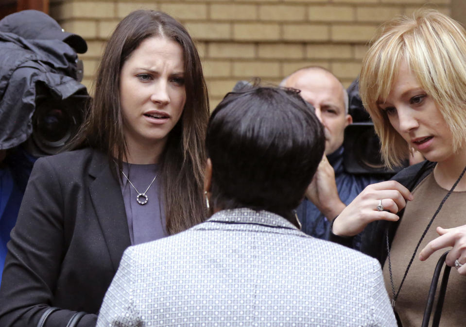 Aimee Pistorius,left, the sister of Oscar Pistorius, speaks with unidentified people as she arrives for his trial at the high court in Pretoria, South Africa, Monday, March 3, 2014. Oscar Pistorius is charged with murder with premeditation in the shooting death of girlfriend Reeva Steenkamp in the pre-dawn hours of Valentine's Day 2013. (AP Photo/Schalk van Zuydam)