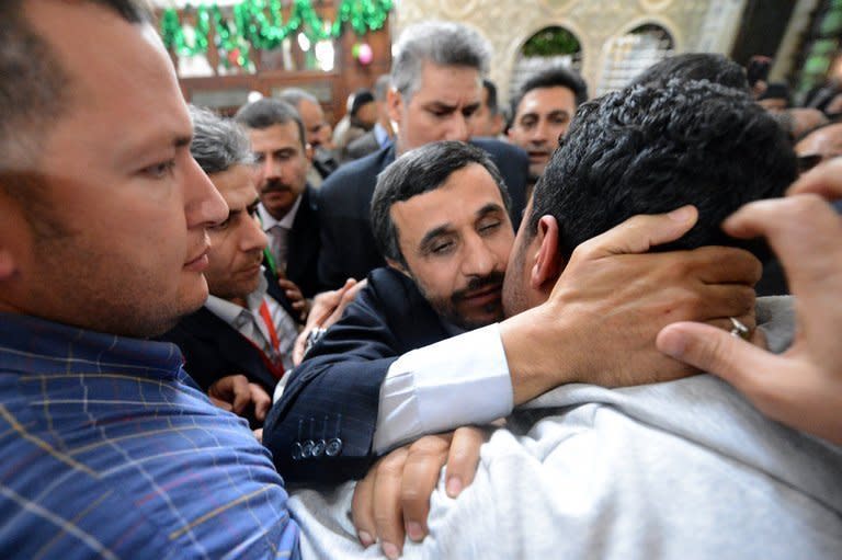 Iranian President Mahmoud Ahmadinejad (centre) kisses an Egyptian man during his visit to the Sayyeda Zeinab mosque in Cairo, on February 5, 2013. Egyptian President Mohamed Morsi has urged Syrian opposition groups to unify, as he addressed leaders of Islamic states at a summit that also tackled the battle against militants in Mali