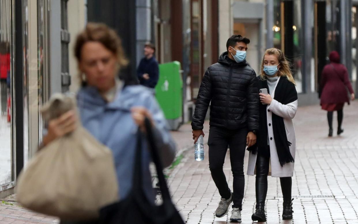 People with and without protective masks walk along the shopping street as the spread of coronavirus continues in Amsterdam - EVA PLEVIER /Reuters