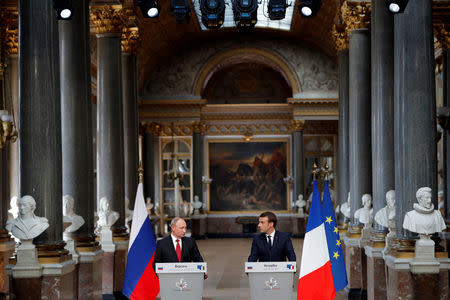 French President Emmanuel Macron (R) and Russian President Vladimir Putin (L) give a joint press conference at the Chateau de Versailles before the opening of an exhibition marking 300 years of diplomatic ties between the two countries in Versailles, France, May 29, 2017. REUTERS/Philippe Wojazer