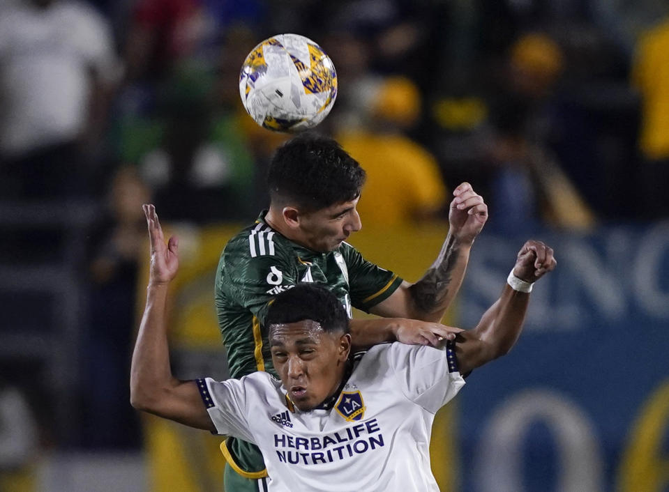 LA Galaxy defender Mauricio Cuevas, bottom, and Portland Timbers defender Claudio Bravo vie for a head ball during the first half of an MLS soccer match Saturday, Sept. 30, 2023, in Carson, Calif. (AP Photo/Ryan Sun)