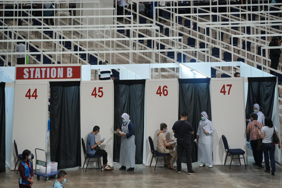 Health staff check at vaccination booths for the coronavirus at a vaccination center in Kuala Lumpur, Malaysia, Monday, May 31, 2021. An exhibition center in Malaysia has been turned into the country's first mega vaccination center as the government aims to speed up inoculations amid a sharp spike in infections. (AP Photo/Vincent Thian)