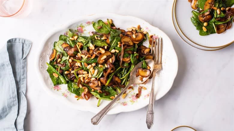 Wilted spinach salad on white plate