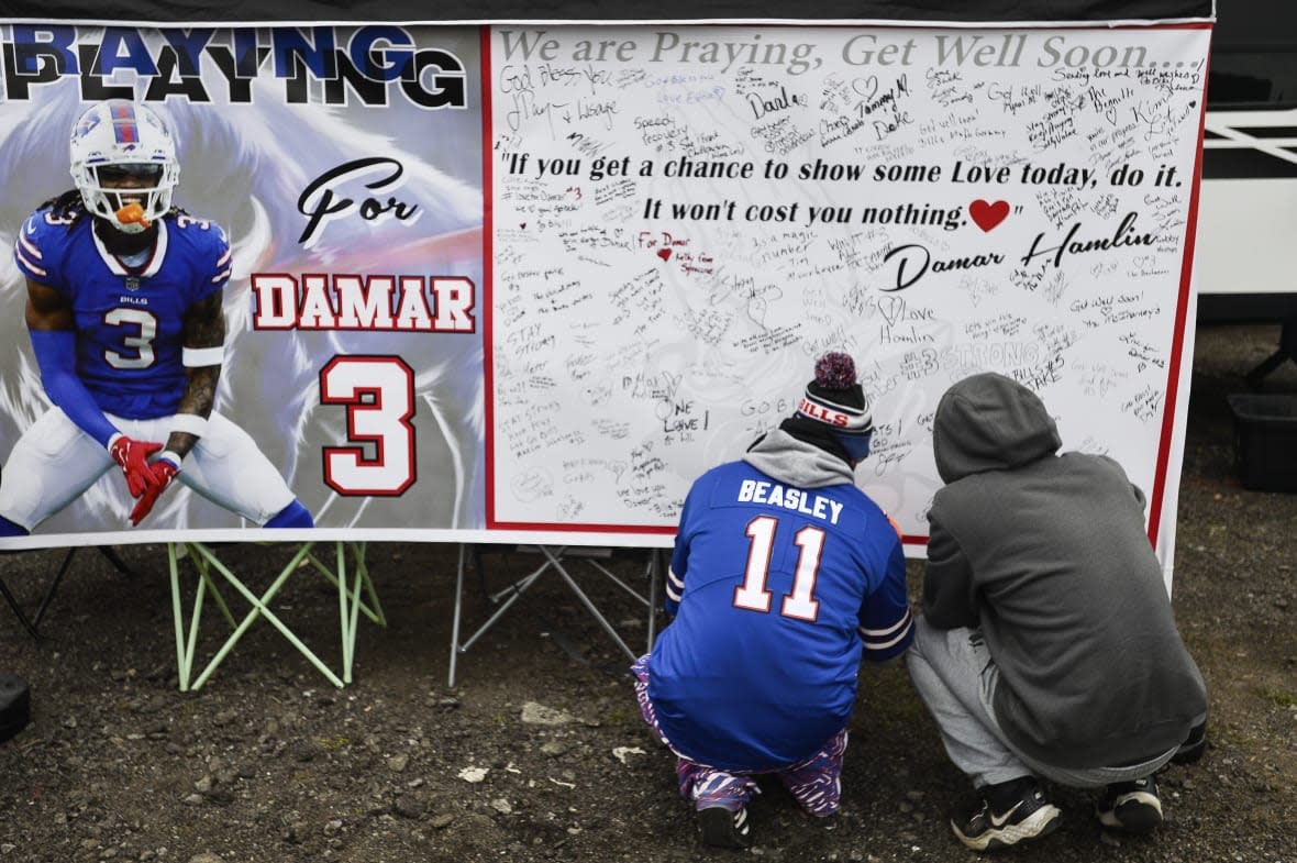 Fans leave messages of support for Buffalo Bills safety Damar Hamlin (3) on a poster outside Highmark Stadium before an NFL football game against the New England Patriots, Sunday, Jan. 8, 2023, in Orchard Park, N.Y. Hamlin remains hospitalized after suffering a catastrophic on-field collapse in the team’s previous game against the Cincinnati Bengals. (AP Photo/Adrian Kraus)