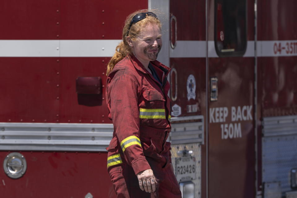 Jodi Whyte, a volunteer firefighter whose day job is a teacher, smiles with soot on her face as she arrives at a command center within the evacuated zone of the wildfire burning in Tantallon, Nova Scotia, outside of Halifax on Wednesday, May 31, 2023. (Darren Calabrese/The Canadian Press via AP)