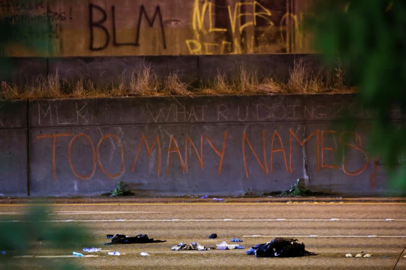 The spray-painted words "too many names" are pictured at the scene where two people in a group of protesters were stuck by a car on Interstate 5, in Seattle