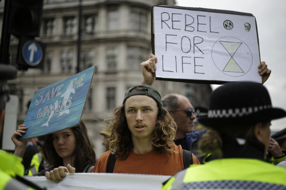 Extinction Rebellion climate change protesters hold banners as they briefly block traffic around Parliament Square in central London, Wednesday, April 24, 2019. The non-violent protest group, Extinction Rebellion, is seeking negotiations with the government on its demand to make slowing climate change a top priority. (AP Photo/Matt Dunham)