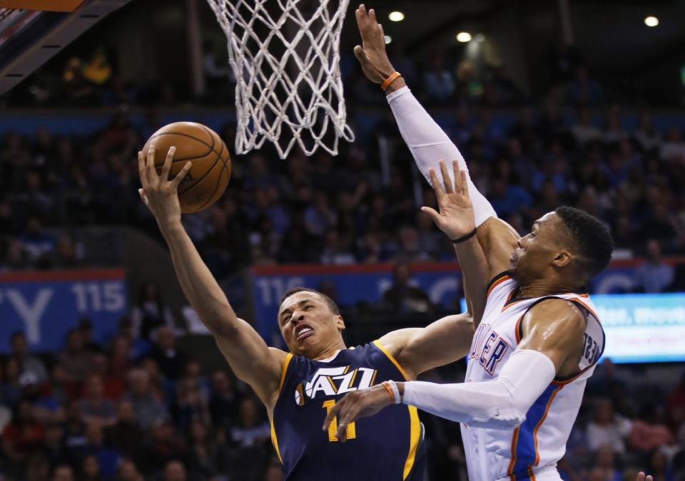 Utah Jazz guard Dante Exum (11) shoots in front of Oklahoma City Thunder guard Russell Westbrook, right, in the fourth quarter of an NBA basketball game in Oklahoma City, Saturday, March 11, 2017. Oklahoma City won 112-104. (AP Photo/Sue Ogrocki)