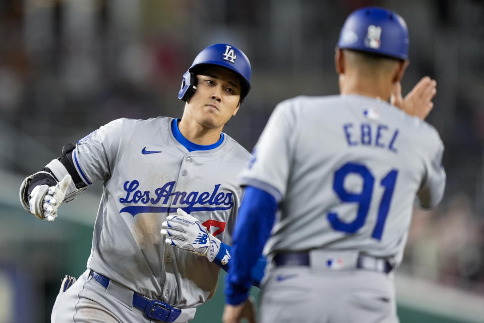 Los Angeles Dodgers designated hitter Shohei Ohtani celebrates with third base coach Dino Ebel, as he runs the bases for his solo home run during the ninth inning of a baseball game against the Washington Nationals at Nationals Park, Tuesday, April 23, 2024, in Washington. The Dodgers won 4-1. (AP Photo/Alex Brandon)