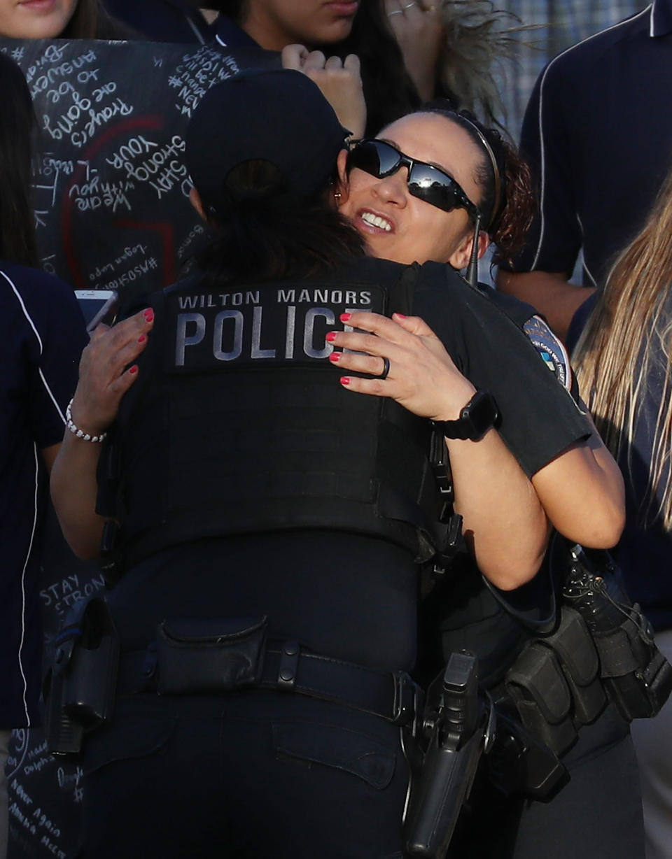 Police officers hug as they stand guard near Marjory Stoneman Douglas High School.