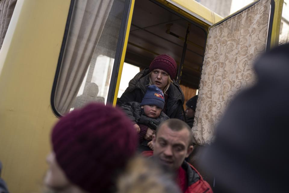 Displaced people disembark from a damaged bus upon their arrival at the Ukrainian Red Cross center in Mykolaiv, southern Ukraine, on Monday, March 28, 2022. (AP Photo/Petros Giannakouris)