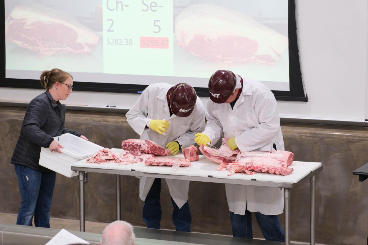 Members of the WT meat judging team dissect a portion of beef Tuesday at a One West Campaign Steering Committee Meeting at West Texas A&M.