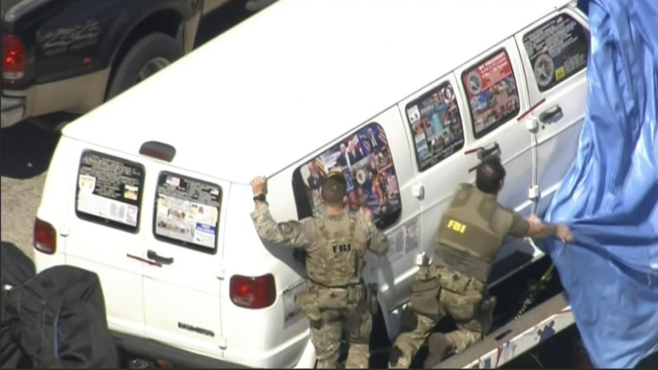 This frame grab from video provided by WPLG-TV shows FBI agents covering the van after the tarp fell off as it was transported from Plantation, Fla., on Friday, Oct. 26, 2018.