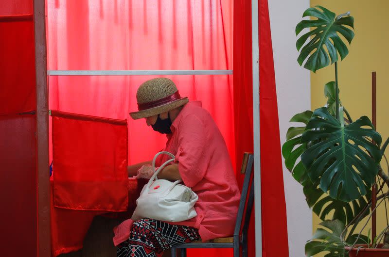 A voter fills in her ballot at a polling station during the presidential election in Minsk