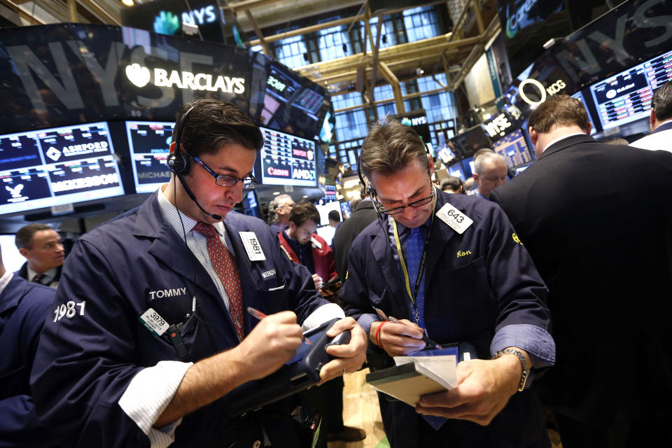 Traders Thomas Donato, left, and Ronald Madarasz work on the floor of the New York Stock Exchange Friday, Jan. 24, 2014. (AP Photo/Jason DeCrow)