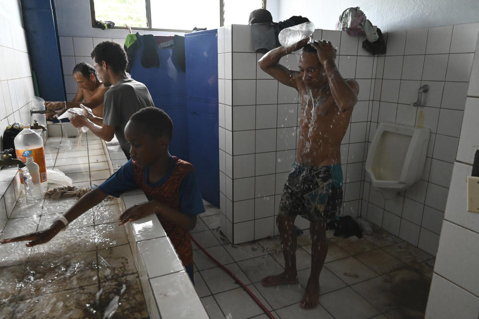 A migrant takes a shower at a Migrant Temporal Attention Center before continuing on his way north to Nicaragua and hopefully to the Mexico-United States border, in Paso Canoas, Costa Rica, Monday, Oct. 16, 2023. Panama and Costa Rica launched a plan to quickly bus thousands of migrants through Panama to the Costa Rican border, as the countries continue to grapple with the increasing number of migrants. (AP Photo/Carlos Gonzalez)