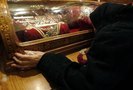 Trieza ,73, an Egyptian Christian grieves while kissing a glass capsule containing cloth belonging to Christian martyrs in the Coptic Orthodox church in Alexandria, 2, 2011. REUTERS/Amr Abdallah Dalsh