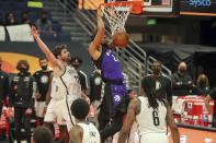 Toronto Raptors' Khem Birch, center, dunks past Brooklyn Nets' Joe Harris (12) during the second half of an NBA basketball game Wednesday, April 21, 2021, in Tampa, Fla. The Raptors won 114-103. (AP Photo/Mike Carlson)