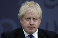 British Prime Minister Boris Johnson delivers a speech at Lydd Airport, south east England, Thursday, April 14, 2022. Britain says it has struck a deal with Rwanda to send some asylum-seekers to the central African country, a proposal that has been condemned by opposition politicians and refugee groups. (AP Photo/Matt Dunham, Pool)