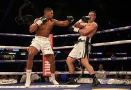 <p>Anthony Joshua throws a left, forcing Joseph Parker to cover up in round 2 </p>