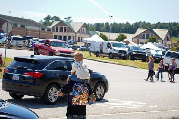 WINDER, GEORGIA - SEPTEMBER 4: A father walks by Apalachee High School with his son on his shoulders as after a school shooting on September 4, 2024 in Winder, Georgia. Multiple fatalities and injuries have been reported and a suspect is in custody according to authorities. (Photo by Megan Varner/Getty Images)S