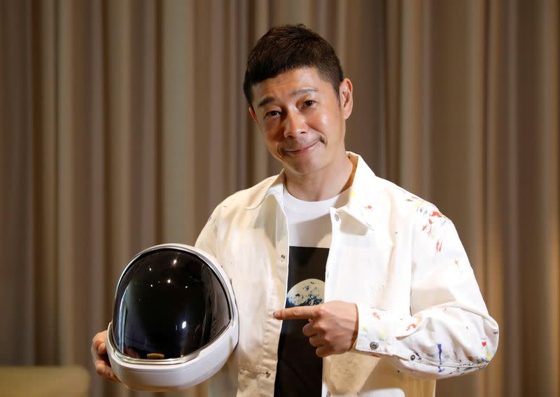 Japanese billionaire Yusaku Maezawa poses with a space suit helmet during an interview with Reuters in Tokyoo