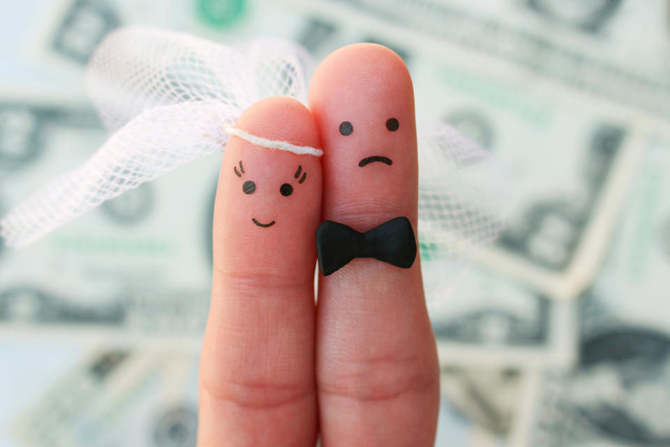 Fingers art of couple on background of money. Concept of woman is happy, and man does not want to get married.