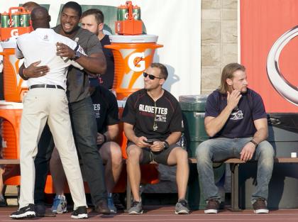 Montreal Alouettes&#39; Michael Sam (2nd L) is given a hug as he watches his team warm-up from the sidelines prior to their CFL football game against the Calgary Stampeders in Montreal, July 3, 2015. Sam, the first openly gay player drafted into the NFL, had been suspended by the Canadian Football League&#39;s Montreal Alouettes earlier this month after the defensive lineman left the team&#39;s training camp last week for unexplained personal reasons.   REUTERS/Christinne Muschi