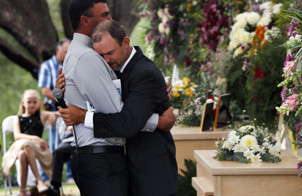 Men embrace next to the coffins of Dawna Ray Langford, 43, and her sons Trevor, 11, and Rogan, 2, who were killed by drug cartel gunmen, during the funeral at a family cemetery in La Mora, Sonora state, Mexico, Thursday, Nov. 7, 2019. Three women and six of their children, all members of the extended LeBaron family, died when they were gunned down in an attack while traveling along Mexico&#39;s Chihuahua and Sonora state border on Monday. (AP Photo/Marco Ugarte)