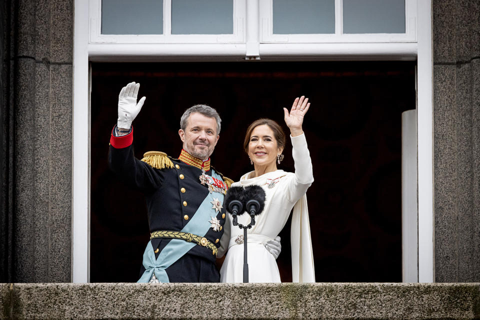 Frederik and Mary wave at the crowds from the palace balcony