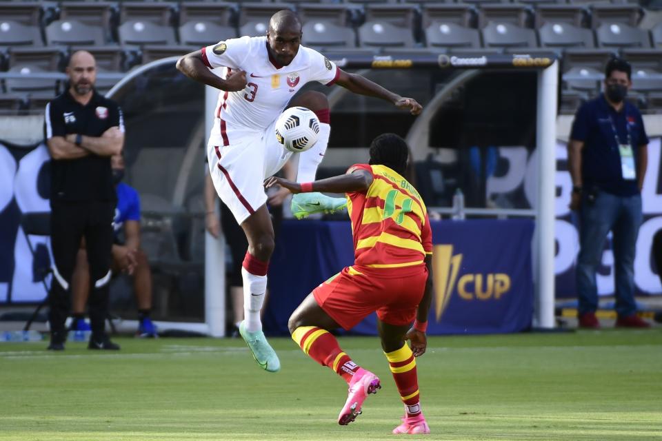 Abdelkarim Hassan, de la selección de Qatar, baja un balón ante Shavon John-Brown, de Granada, en un partido de la Copa de Oro, realizado el sábado 17 de julio de 2021, en Houston (AP Foto/Justin Rex)
