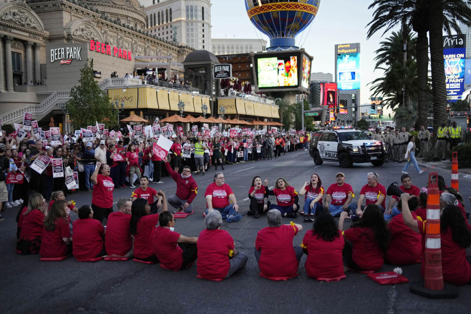 Members of the Culinary Workers Union block traffic along the Strip, Wednesday, Oct. 25, 2023, in Las Vegas. Thousands of hotel workers fighting for new union contracts rallied Wednesday night on the Las Vegas Strip, where rush-hour traffic was disrupted when some members blocked the road before being detained by police. (AP Photo/John Locher)